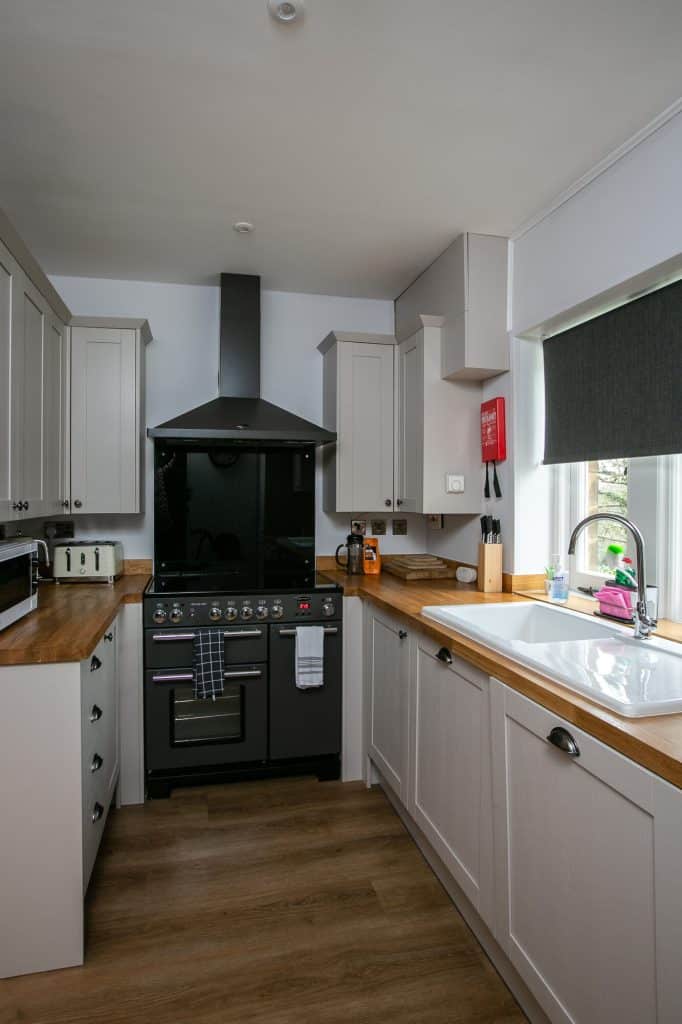 inside of a property where you can see a kitchen living area, stove, kitchen appliances