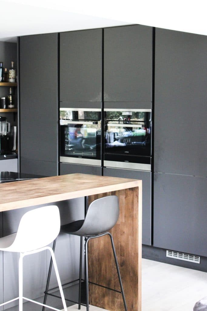 kitchen interior with grey cupboards and a grey and white stool