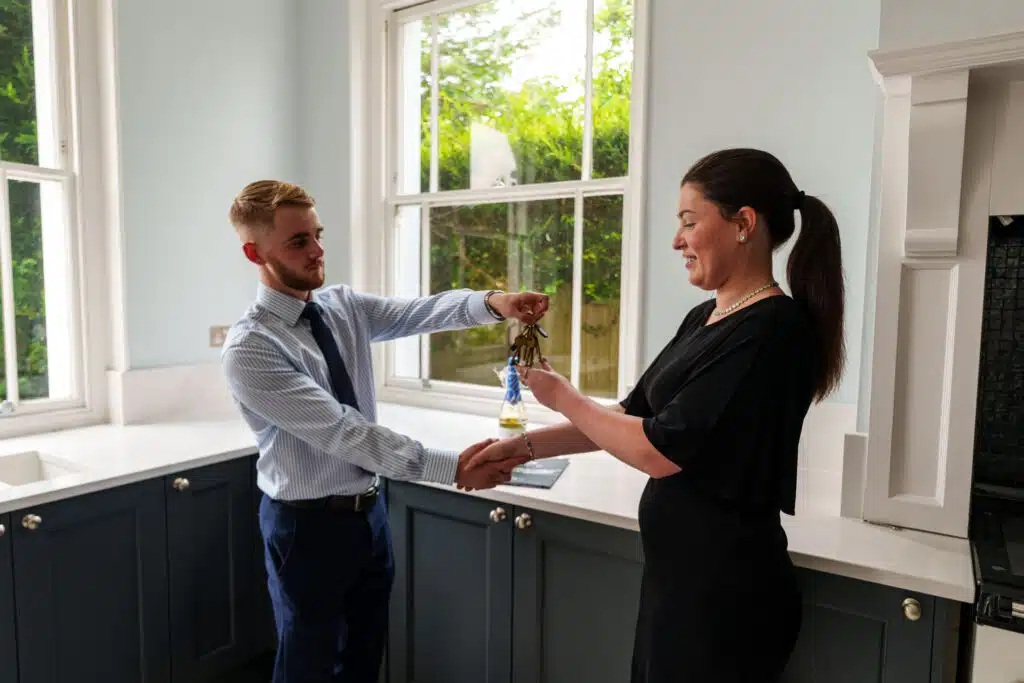 Estate agent handing over keys for chain-free property